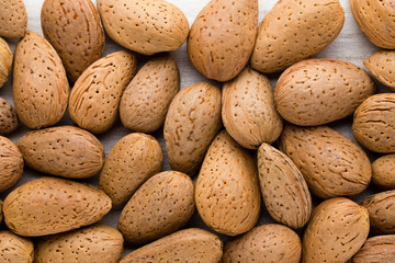 Group of almond nuts with leaves.Wooden background.