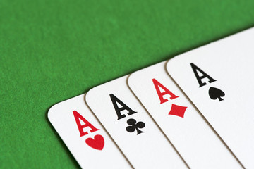 Playing card on green table, four a kind aces