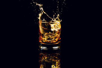 Isolated shot of whiskey with splash on black background