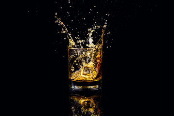 Isolated shot of whiskey with splash on black background