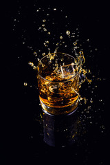Isolated shot of whiskey with splash on black background