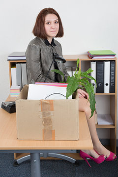 Woman carrying office belongings after loosing job