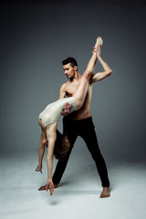 Flexible young modern acrobats couple posing in studio. Fashion portrait of attractive dancing...
