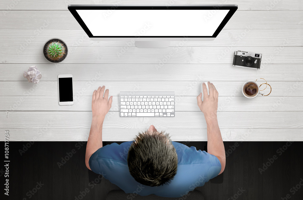 Poster man work on computer with white isolated screen. work desk with plant, camera, coffee, smart phone. 