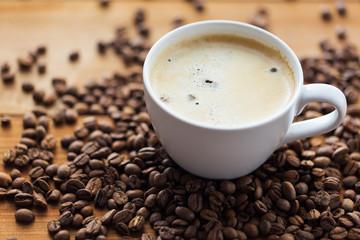 close up coffee cup and grains on wooden table