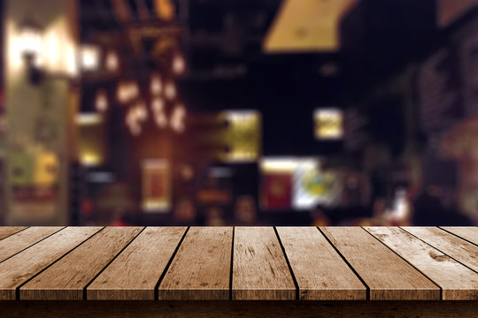 wooden table in blur resturant lights background