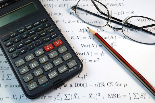 Eye Glasses, pen and pencil over the Formula with calculator