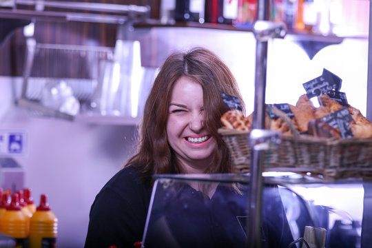 Laughing woman behind the cafe bar counter