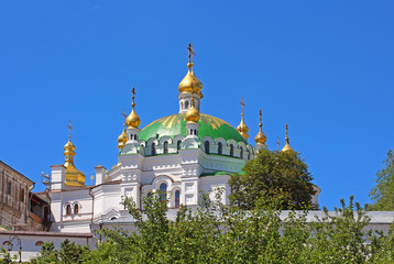 Fototapeta na wymiar Orthodox domes with golden crosses of the Refectory church and the Assumption cathedral of Kyiv Pechersk Orthodox monastery in Kyiv, Ukraine
