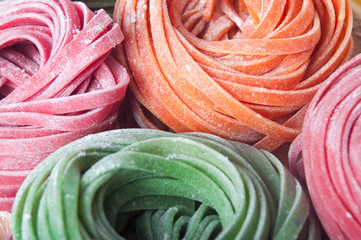 Closeup of varicolored raw italian pasta with vegetable dyes