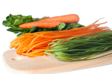 Orange and green raw italian pasta with spinach and carrot
