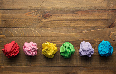 Colorful crumpled paper on a wooden table