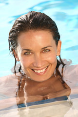portrait de femme souriant dans l'eau d'une piscine