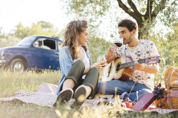 Young couple in love doing a picnic outdoors in Tuscany wine country