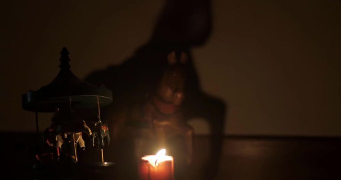 4k antico carillon e cavallo di legno che proietta ombra da fiamma di candela