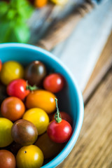 Fresh vine and cherry tomatoes on chopping board