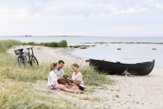 Family playing cards on beach