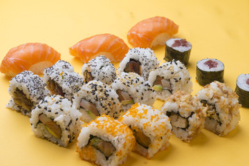 Different Sushi rolls,wasabi and ginger on a plate on wooden bac