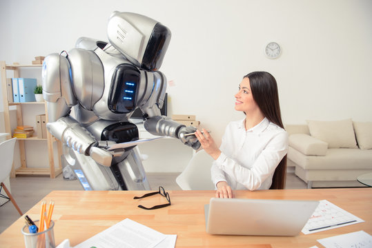 Positive girl and robot working in the office