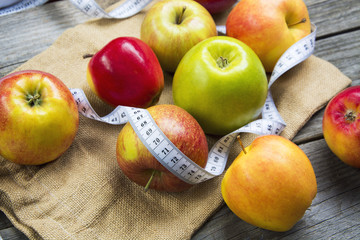 Apples with tape measure, Open notebook for notes. The concept of a healthy lifestyle and losing weight. Free space for text. Copy space. selective soft focus
