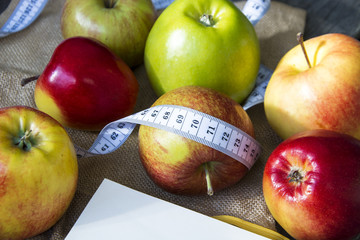 Apples with tape measure, Open notebook for notes. The concept of a healthy lifestyle and losing weight. Free space for text. Copy space. selective soft focus