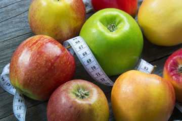 Apples with tape measure, Open notebook for notes. The concept of a healthy lifestyle and losing weight. Free space for text. Copy space. selective soft focus