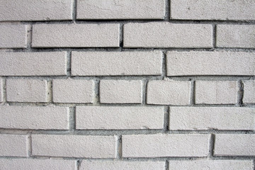 Wall of white brick. Background of white bricks. Texture of brick wall close. Sturdy wall of a building. The bricks are laid manually. Manual brickwork walls during construction.