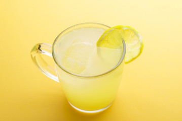 Water and lemon in yellow background