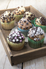 Photo of tasty cupcakes with chocolate over wooden table