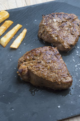 cooked beef chateaubriand steak with chunk chipped potatoes on p