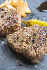 Grilled T-bone steak seasoned with spices and fresh herbs served