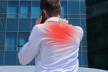 Man with  back pain. Business man rubbing his painful neck 