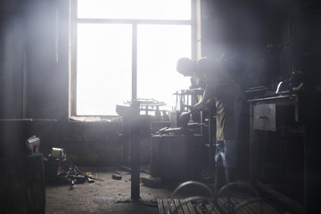 The blacksmith in the production of Handicrafts made of metal on the anvil in the workshop