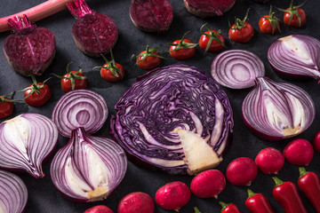 Red vegetables cut in halves, flat lay design