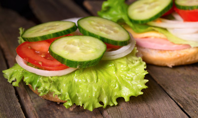 Sandwich with salad and other vegetables on old gray boards