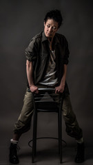 Androgynous character on a gray background. Man or woman. Military style. Very sharp.  