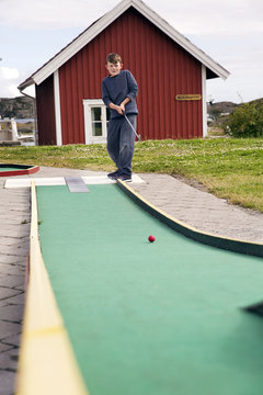 Boy playing minigolf