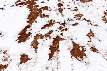 snow on red clay in nature