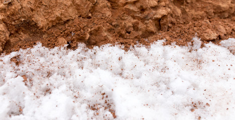 snow on red clay in nature