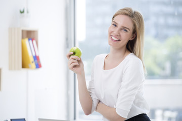 Business woman having healthy snack, eating apple