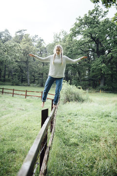 Woman balance on a fence