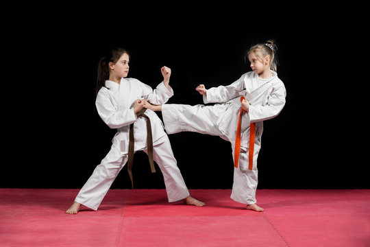 Two girls in kimono are training paired exercises karate