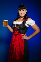 Beautiful brunette woman in Bavarian dressed with glass of beer