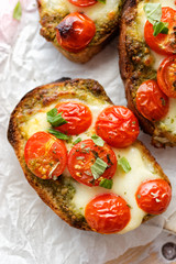 Bruschetta with cherry tomatoes, mozzarella cheese and herb pesto