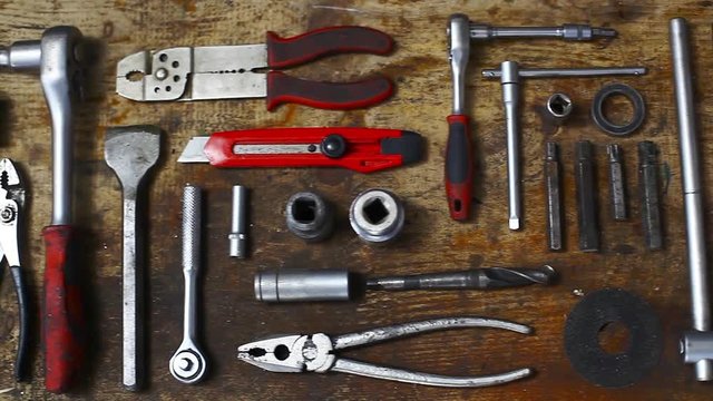 Sliding footage of many tools on a wooden plank.