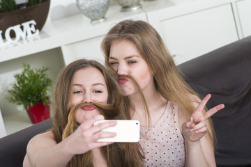 Mädchen machen Selfies mit dem Smartphone und albern dabei als BFF