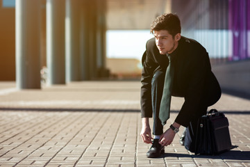 Businessman walking and holding a leather briefcase in his hand
