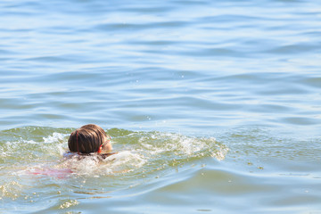 Little girl kid swimming in sea water. Fun