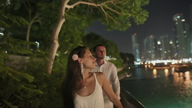 Young man and woman walking in the night Dubai
