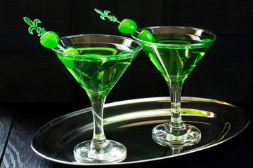 Green cocktail with maraschino cherry in a martini glasses